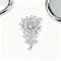 Detail of silver floral brooch with shimmering crystals and elegant petal design - White