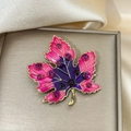 Detailed close-up of a maple leaf brooch with enamel gradient and purple rhinestones - Rose Red