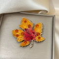 Detail of maple leaf brooch with enamel gradient and rhinestones on satin - Orange