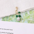 Detail van roze bloembedeltje met wit emaille en groene bladeren op gouden basis - Lichtblauw met Rozenborduursel