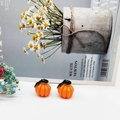 Detail of orange resin pumpkin charm with green leaf and silver ring on blue magazine - Dark Green Leaf Pumpkin