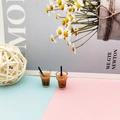 Macro shot of miniature bubble tea cups for dollhouses featuring brown liquid and pearls - Brown