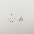 Detailed view of white cherry blossom alloy charms with gold plating and enamel fill - White Small Cherry Blossom Style