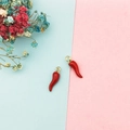 Detailed macro view of two red chili alloy charms with gold rings for DIY jewelry making - Red