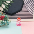 Dettaglio di un ciondolo a mini bottiglia dei desideri con paillettes rosa e stelline - Rosso