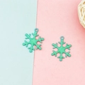 Nahaufnahme von grünen Glitzer-Schneeflocken-Anhängern für DIY-Schmuckherstellung - Blau
