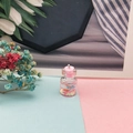 Dettaglio del ciondolo a forma di mini bottiglia dei desideri con liquido rosa e paillettes - Rosa