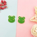 Detail view of two green enamel frog pendants with gold trim for handmade DIY jewelry - Frog