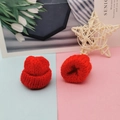 Detail view of two mini red knitted hats for DIY crafts and doll accessories - Red