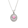 Macro shot of silver oval pendant with pink heart and textured sunburst engraving - Steel Pink Heart