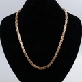 Collier chaîne byzantine dorée en acier inoxydable présenté sur un support de buste noir - Tout Or