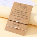 Détail de bracelets cœur pour couples sur carte cadeau en papier kraft avec message - Noir et Blanc