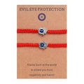 Détail de bracelets Hamsa tressés rouges avec breloques œil bleu sur carte - Rouge
