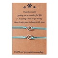 Detailed view of handmade light blue cord bracelets with silver paw charms on a kraft card - Blue Line