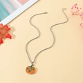 Détail macro du pendentif citrouille en émail orange avec chaîne argentée d'automne - Style de Citrouille Argenté