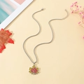 Détail du pendentif feuille d'érable en émail rouge et jaune sur chaîne à billes - Feuille d'Érable Argentée