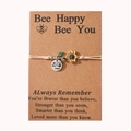 Detail of bee and sunflower charms on a braided bracelet with a gift backing card - Khaki