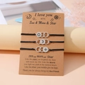 Detailed view of sun, moon and star charms on woven friendship bracelets with card - I Love You Style (B00536) / Set of 3 / Black