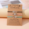 Close-up of three woven sun moon and star friendship bracelets on a gift card board - I Love You Style (B00536) / Set of 3 / Multicolor