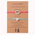 Detalle de las pulseras trenzadas Mommy & Me con corazón sobre tarjeta de regalo y silueta - Rojo Rosa + Azul