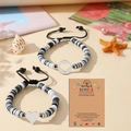 Détail de bracelets perlés pour la rentrée avec breloques cœur sur carte cadeau - École / Noir