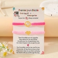 Details der rosa gewebten Herz-Armbänder auf einer zweisprachigen Kindergarten-Geschenkkarte - Herz Rosarot + Rosa (Gold)