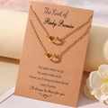 Golden heart knot necklace set on Pinky Promise card with warm aesthetic decor - Necklace And Card / Gold Pinky Promise Theme
