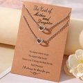 Close-up of heart knot necklaces on a sentimental Mother and Daughter gift card - Necklace And Card / Steel Mother Daughter Theme