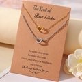 Detail of gold and silver knot necklaces displayed on a friendship gift card - Necklace And Card / Steel And Gold Best Bitch Theme