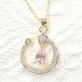 Macro shot of gold moon and star necklace with pink teardrop crystal and zircons - Pink Teardrop Style