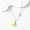 Macro shot of gold butterfly necklace with honeycomb texture and paperclip chain - Butterfly Shadow Necklace
