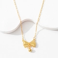Detailed macro view of a gold bow pendant featuring dot texture and a small gold ball drop - Tassel Bowknot Necklace