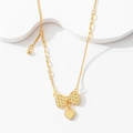 Close-up of gold bow necklace with heart pendant and textured diamond pattern chain - Heart Bowknot Necklace
