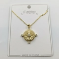 Macro shot of gold compass star pendant with small white rhinestones on display card - Octagram Pendant With Chain And Box