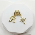 Macro view of gold plated pendant with pavé zircon letter R and North Star details - Script Letter R (Style 4)