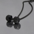 Close-up of black stainless steel dumbbell pendant with detailed circular engraving - Black Color Necklace with Pendant