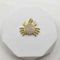 Gold crab pendant with white cubic zirconia inlay on a white geometric stand - White Zirconia Crab Pendant