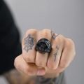 Macro detail of men's matte black reaper skull ring featuring gothic embossed textures - Black