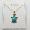 Golden sea turtle pendant necklace with turquoise stone inlay on a display card - Artificial Turquoise Turtle Pendant + Chain + Packaging