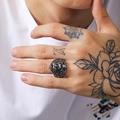Detailed close-up of a masculine punk lion head ring on a tattooed hand - US 10 / Steel
