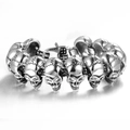 Dettaglio ravvicinato del bracciale punk da uomo con teschi in acciaio inossidabile argento - Colore acciaio