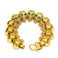 Vista dettagliata del bracciale a teschi dorati con occhi in gemma verde e chiusura - Oro Verde