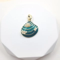Golden sea shell pendant with turquoise glaze and white pearls on white podium - Shell Style 7