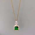 Macro view of gold halo necklace with square green gemstone and white zircon accents - Green