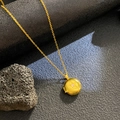 Primer plano del collar de relicario dorado con relieve de estrella y circón - Estrella Redonda Circonita