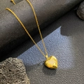 Detalle de colgante de corazón dorado con mariposa de circonitas y cadena de eslabones - Corazón de Mariposa Circonita