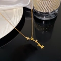 Detail van gouden klaverketting met vijf gebogen bloemenhangers en micro-pave zirkonia's - Halsketting met vijf bloemenstrass-steentjes (X2030)