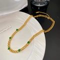 Gros plan du collier à grosse chaîne dorée avec cinq breloques cœurs en zircon vert - Collier avec Cinq Coeurs Verts (X2181)