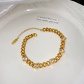 Détail d'un bracelet en acier inoxydable doré avec cinq breloques en zircone en cœur - Bracelet avec Cinq Zircons Coeurs Blancs (X2178)