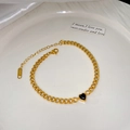 Détail de bracelet à chaîne gourmette dorée avec pendentif cœur noir et logo en acier - Bracelet Coeur Noir (X2174)